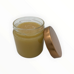 Cremiger Sommerblütenhonig von Bienenprodukte Shop im Glas mit goldfarbenem Deckel auf hellem Hintergrund